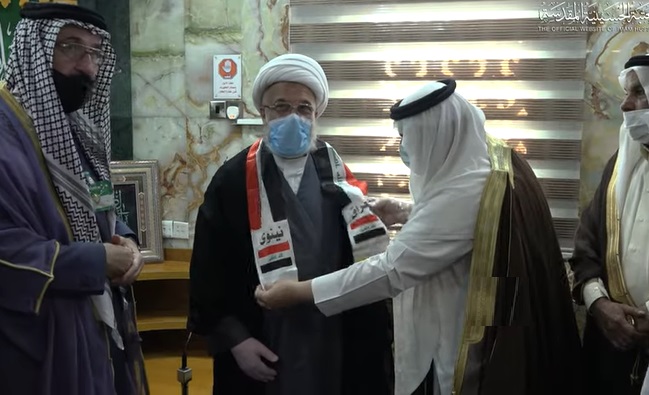 بالصور:وفد من قبائل الموصل يقلدون ممثل المرجع السيستاني العلم العراقي:الشيخ الكربلائي يامر بانشاء مستشفيين بجانبي الموصل لعلاج كورونا